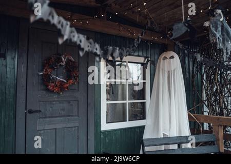 Gruselig fliegende hängende Spielzeug Geist.Dekorieren der Veranda auf der Straße für halloween Holiday.bat Girlande, Kranz aus alten leaves.DIY Haus, Straße dekorieren Stockfoto