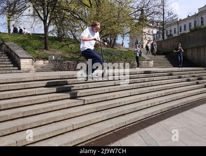 Krakau. Krakau. Polen. Junger Mann springt mit seinem Roller über die Treppe. Scooter-Trick. Stockfoto