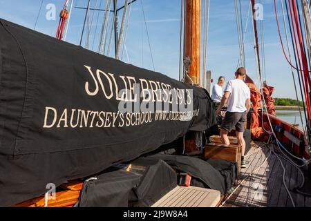 Crew, die am Vordereck arbeitet, um an Bord der berühmten Gaffelschneiderei „Jolie Brise“ auf dem River Hamble, Hampshire, Großbritannien, zu segeln Stockfoto