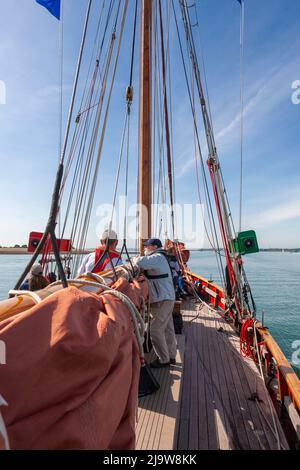 Freuen Sie sich an Bord der berühmten Gaffelschneiderin „Jolie Brise“, die den River Hamble, Hampshire, Großbritannien, hinunterfährt Stockfoto