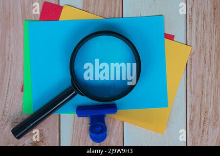 Farbenfrohe Haftnotiz Mit Vergrößerungsglas Auf Holzschreibtisch. Geschäftskonzept. Stockfoto