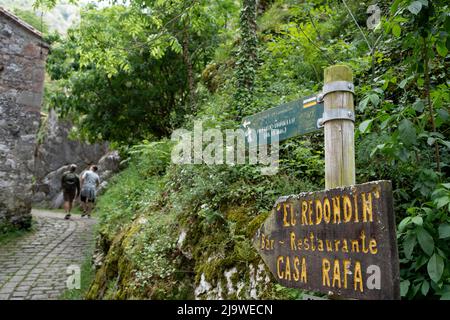 Am 15.. Mai 2022 passieren Wanderer das spanische Bergdorf Bulnes, ein beliebtes spanisches Wanderziel für Besucher des Nationalparks Picos de Europa in Bulnes, Picos Mountains, Asturien, Spanien. Das kleine Dorf Bulnes, das über einen Pfad oder eine Seilbahn erreicht wird, bietet vorbeifahrenden Spaziergängern Betten und Verpflegung. Stockfoto