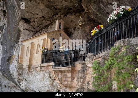 Gläubige Christen besuchen am 16.. Mai 2022 die Santa Cueva de Nuestra Señora de Covadonga (die heilige Höhle unserer Lieben Frau von Covadonga), ein katholisches Heiligtum an den Klippen, in Vovadonga, Picos Mountains, Asturien, Spanien. Der Schrein ist eine Höhle, deren Name der Jungfrau von Covadonga gewidmet ist, wo im Jahr 718 die erste Schlacht der spanischen Wiedereroberung der Mauren stattfand. Stockfoto