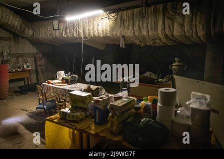 Innenansicht eines Wohnbereichs in einem unterirdischen Bunker in Charkiw. Eine ehemalige Schule wurde jetzt zu einem Bunker, da sie mehr als 100 Bürger beherbergt, die im Bezirk Saltivka in Charkiw leben und gezwungen wurden, unter ständiger schwerer Beschuss russischer Bombardierungen und Luftangriffe ein neues Leben im Untergrund in Bunkern ohne Strom und Wasser zu übernehmen. Stockfoto