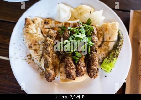 Shish Kofte (SIS Kofte auf Türkisch) in Antalya, Türkei. SIS Kofte ist ein beliebtes lokales Fleischgericht in der Urlaubsstadt Antalya, Türkei. Stockfoto