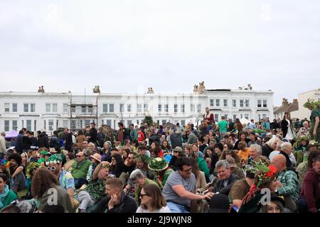 Menge sitzen und zu warten, auf dem Hügel für die Ankunft von Jack in der Grünen Prozession, West Hill, Hastings, East Sussex, Großbritannien Stockfoto