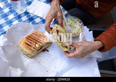 Ein Kunde genießt ein Sandwich im berühmten italienisch-amerikanischen Delikatessengeschäft, Molinari Delicatessen, im North Beach-Viertel von San Francisco, Kalifornien. Stockfoto