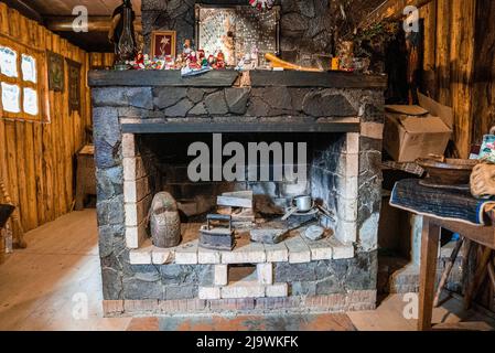 Steinmauer Kamin mit antiken Werkzeugen in verlassenen Zimmer Stockfoto