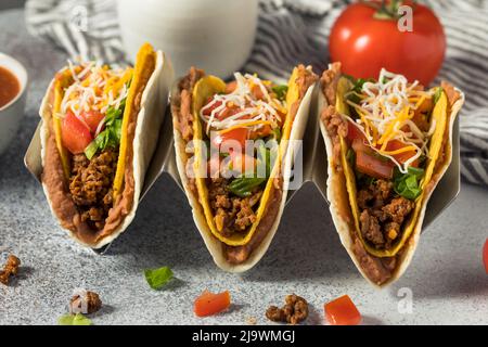 Hausgemachte, doppelt gefüllte Rindfleisch-Tacos mit harten und weichen Schalen mit Gemüse Stockfoto