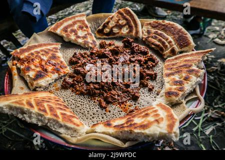 Traditionelles Essen - geschmortes Fleisch mit Injeira in Asmara, Eritrea Stockfoto