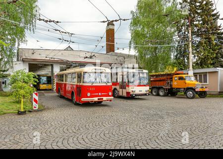 Marienbad, Tschechische Republik - Mai 21 2022: Zwei Skoda-Trolleybusse, 9Tr und 14Tr, stehen vor einer Garage auf grauem Pflastersteinpflaster. Jahrestag von Stockfoto