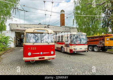 Marienbad, Tschechische Republik - Mai 21 2022: Zwei Skoda-Trolleybusse, 9Tr und 14Tr, stehen vor einer Garage auf grauem Pflastersteinpflaster. Jahrestag von Stockfoto