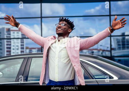 Glücklich und erfolgreich afro amerikanischen Geschäftsmann freut sich und genießen Erfolg vor dem Auto. Konzept eines guten Deal und Sieg Stockfoto