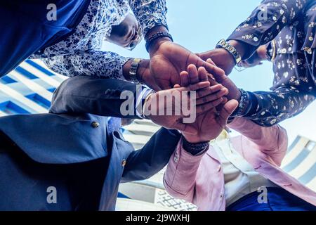 Eine Gruppe von vier schwarzen afro amerikanischen Freunden Männer Geschäftsleute in stilvollen Business-Anzug, teure Armbanduhr Handschlag Teamarbeit .Konzept der erfolgreichen Stockfoto