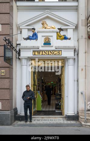 Vor dem dekorativen Eingang zum Flagship-Tee- und Café Twinings steht ein einträchtiger Mann. Strand, London WC2, England, Großbritannien Stockfoto