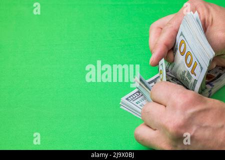 Nahaufnahme der Hände des Menschen zählen Dollar-Banknoten auf Chrom-Schlüssel Hintergrund. Stockfoto