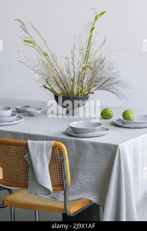 Elegantes Tischgedecke mit frischem Spargelboquet in einer Vase, Cherimoya-Früchte auf Leinentischdecke. Outdoor-Tisch Einstellung für Sommerurlaub conce Stockfoto