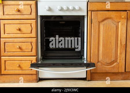 Eingebauter Gasofen und alte hölzerne Küchenschränke in der Küche zu Hause, Küche, Gasherd Stockfoto