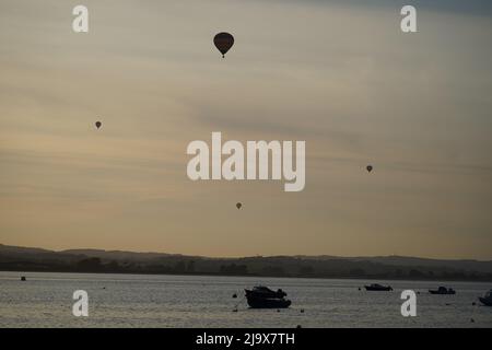 Eine Gruppe von Heißluftballons, die über den River exe fliegen, aus dem Dorf Lympstone, Devon, Großbritannien Stockfoto
