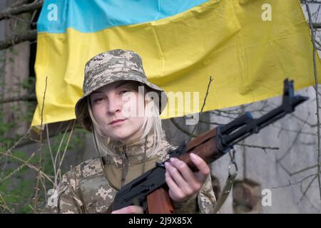 Porträt einer Soldatinnen in Tarnuniform, die auf die Kamera schaut Stockfoto