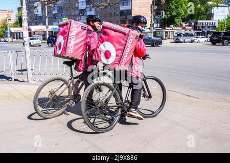 Samara, Russland - 24. Mai 2022: Kuriere von Samokat Food Delivery Service auf Fahrrädern auf der Straße der Stadt Stockfoto