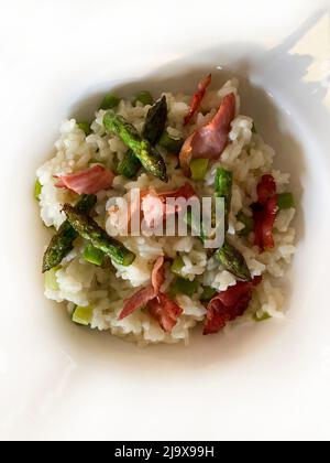 Risotto mit Spargel und Speck. Italienisches Frühlingsgericht. Direkt darüber. Stockfoto