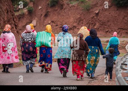 Gruppe von Berberfrauen, die auf einer asphaltierten Straße arbeiten, Ait Blal, Provinz azilal, Atlasgebirge, marokko, Afrika Stockfoto