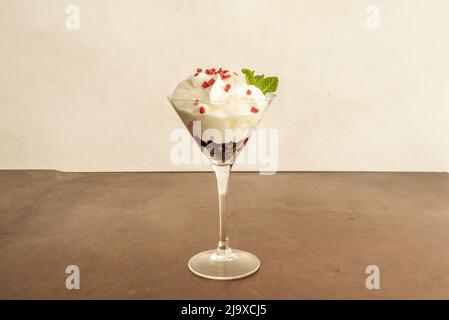 Tasse cremiger Joghurt mit Erdbeerchips und Schokoladenhintergrund Stockfoto