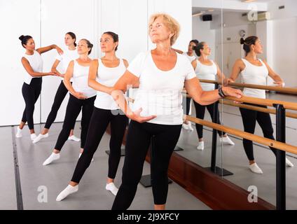 Frauen trainieren Ballettbewegungen mit Trainer Stockfoto