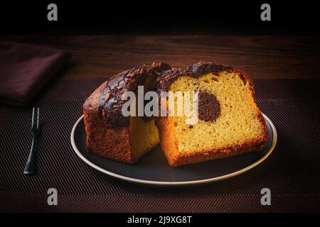 Hausgemachte Schokolade Marmorkuchen. Schokolade Vanille Pfannkuchen auf einem Teller auf einem feinen Tisch, feines Gebäck Stockfoto