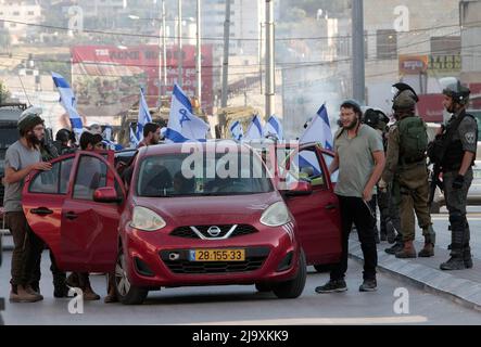 Nablus, Palästina. 12.. Mai 2022. Jüdische Siedler demonstrieren während eines "Marsches um die Flaggen" mitten auf dem Markt in der Stadt Hawara, südlich von Nablus im Westjordanland. (Foto von Nasser Ishtayeh/SOPA Images/Sipa USA) Quelle: SIPA USA/Alamy Live News Stockfoto
