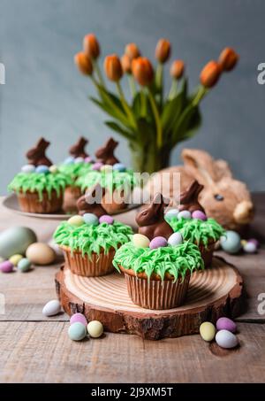 Zu ostern dekorierte Cupcakes mit Süßigkeiteneiern und Schokoladenhasen. Stockfoto