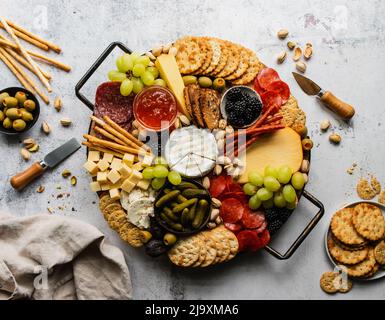 Overhead of Charcuterie Board von Käse, Fleisch, Cracker und Obst. Stockfoto