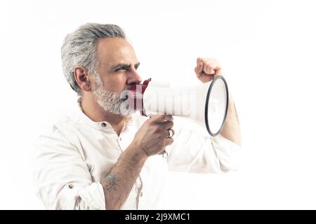 Europäischer Mann mittleren Alters, der über Lautsprecher auf weißem Hintergrund schreit. Werbekonzept. Hochwertige Fotos Stockfoto