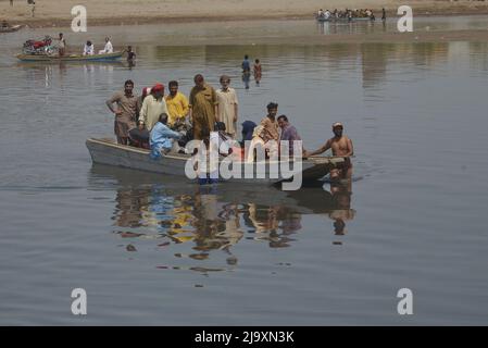 25. Mai 2022, Lahore, Punjab, Pakistan: Pakistanische Menschen, die ihre Waren in Booten transportieren, um den Ravi-Fluss zu überqueren, während sie aufgrund der Sperrungen von Routen nach der Umsetzung von Artikel 144 aufgrund von Sicherheitsmaßnahmen für den Protest und den langen marsch der PTI in Richtung Islamabad von Lahore festsitzen. Die pakistanischen Behörden blockierten am Mittwoch alle wichtigen Straßen in die Hauptstadt Islamabad, nachdem ein trotziger ehemaliger Premierminister Imran Khan sagte, er werde mit Demonstranten zu einer Kundgebung ins Stadtzentrum marschieren, von der er hofft, dass sie die Regierung zum Fall bringen und vorgezogene Wahlen forcieren wird. (Bild: © Rana Sajid Hussai Stockfoto