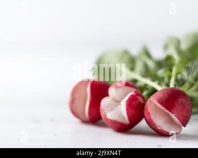 Gerissene Rettich auf einer weißen Holzoberfläche Stockfoto