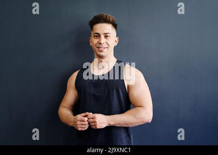 Porträt Eines glücklichen jungen Mannes in Sportswear auf schlichem Hintergrund Stockfoto