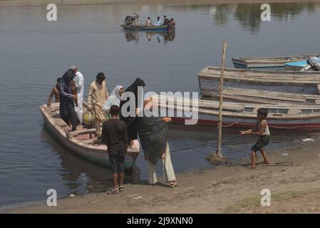 25. Mai 2022, Lahore, Punjab, Pakistan: Pakistanische Menschen, die ihre Waren in Booten transportieren, um den Ravi-Fluss zu überqueren, während sie aufgrund der Sperrungen von Routen nach der Umsetzung von Artikel 144 aufgrund von Sicherheitsmaßnahmen für den Protest und den langen marsch der PTI in Richtung Islamabad von Lahore festsitzen. Die pakistanischen Behörden blockierten am Mittwoch alle wichtigen Straßen in die Hauptstadt Islamabad, nachdem ein trotziger ehemaliger Premierminister Imran Khan sagte, er werde mit Demonstranten zu einer Kundgebung ins Stadtzentrum marschieren, von der er hofft, dass sie die Regierung zum Fall bringen und vorgezogene Wahlen forcieren wird. (Bild: © Rana Sajid Hussai Stockfoto