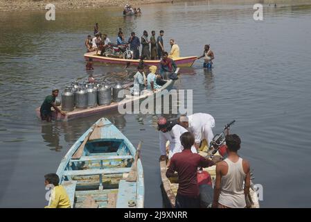 25. Mai 2022, Lahore, Punjab, Pakistan: Pakistanische Menschen, die ihre Waren in Booten transportieren, um den Ravi-Fluss zu überqueren, während sie aufgrund der Sperrungen von Routen nach der Umsetzung von Artikel 144 aufgrund von Sicherheitsmaßnahmen für den Protest und den langen marsch der PTI in Richtung Islamabad von Lahore festsitzen. Die pakistanischen Behörden blockierten am Mittwoch alle wichtigen Straßen in die Hauptstadt Islamabad, nachdem ein trotziger ehemaliger Premierminister Imran Khan sagte, er werde mit Demonstranten zu einer Kundgebung ins Stadtzentrum marschieren, von der er hofft, dass sie die Regierung zum Fall bringen und vorgezogene Wahlen forcieren wird. (Bild: © Rana Sajid Hussai Stockfoto