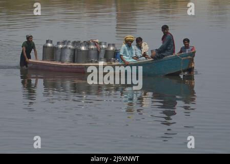 25. Mai 2022, Lahore, Punjab, Pakistan: Pakistanische Menschen, die ihre Waren in Booten transportieren, um den Ravi-Fluss zu überqueren, während sie aufgrund der Sperrungen von Routen nach der Umsetzung von Artikel 144 aufgrund von Sicherheitsmaßnahmen für den Protest und den langen marsch der PTI in Richtung Islamabad von Lahore festsitzen. Die pakistanischen Behörden blockierten am Mittwoch alle wichtigen Straßen in die Hauptstadt Islamabad, nachdem ein trotziger ehemaliger Premierminister Imran Khan sagte, er werde mit Demonstranten zu einer Kundgebung ins Stadtzentrum marschieren, von der er hofft, dass sie die Regierung zum Fall bringen und vorgezogene Wahlen forcieren wird. (Bild: © Rana Sajid Hussai Stockfoto