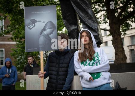 London, Großbritannien. 25. Mai 2022. Zwei junge Demonstranten haben sich in Whitehall versammelt, um gegen den anhaltenden Krieg Russlands in der Ukraine zu protestieren, und haben ein Zeichen gesetzt, um die russischen Öl- und Gasimporte zu stoppen. Quelle: Kiki Streitberger / Alamy Live News Stockfoto