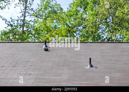 Neu installiertes Dach mit Asphaltschindeln mit Bitumenfliesen auf dem Dach des neuen Hauses Stockfoto