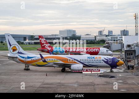 Kommerzielle Airbus-Flugzeuge vom Typ A320-200 für Thai AirAsia (FD) und NokAir werden am Don Mueang International Airport (DMK) in Bangkok vor den nationalen Abfluggates geparkt. Internationale Reisen nach Thailand und inländischer Tourismus im Land werden wieder aufgenommen, da die thailändische Regierung die Einreisebestimmungen im Rahmen ihres Thailand Pass-Programms vereinfacht, so dass internationale Reisende das Land ohne einen schnellen PCR-Test für COVID-19 oder Quarantäne bei der Ankunft betreten können. Die thailändische Regierung hat auch signalisiert, dass die Auflage, Gesichtsmasken im Freien zu tragen, voraussichtlich Mitte Juni 2022 enden wird. (Foto von Matt Hunt Stockfoto