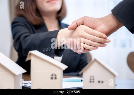 Zum Abschluss eines Geschäftskonzepts schüttelte Immobilienmakler nach Vertragsunterzeichnung die Hände seines Kunden. Stockfoto