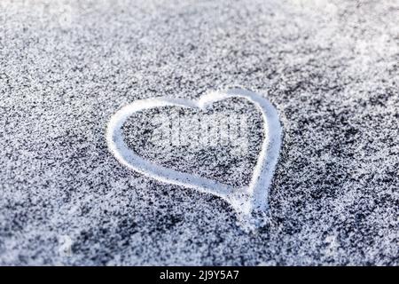 Schwarzer Ruß aus dem Kesselraum auf weißem Schnee. Natürlicher Hintergrund. Schnee gemischt mit Kohleroß, schlechte Ökologie. Umweltverschmutzung. Ein Herz ist schmerzhaft Stockfoto