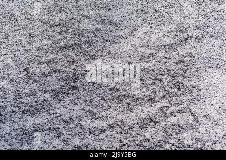 Schwarzer Ruß aus dem Kesselraum auf weißem Schnee. Natürlicher Hintergrund. Schnee gemischt mit Kohleroß, schlechte Ökologie. Umweltverschmutzung Stockfoto