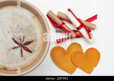 Tasse Kaffee mit Gewürzen, romantische Noten mit Wünschen und zwei Herzen aus getrockneten Orangenschalen Stockfoto