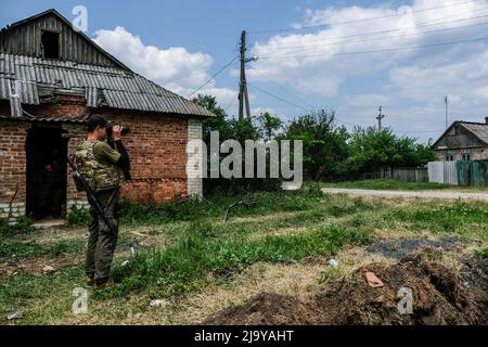 Soledar, Ukraine. 24.. Mai 2022. Ein Soldat schaut durch ein Fernglas. Soledar ist eine Stadt der Region Donetsk, die von russischer Artillerie gehämmert wird, da sie sich entlang der entscheidenden Straße befindet, die aus dem belagerten Severodonetsk führt. Kredit: SOPA Images Limited/Alamy Live Nachrichten Stockfoto