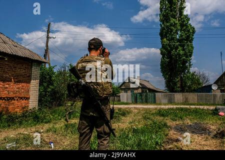 Soledar, Ukraine. 24.. Mai 2022. Ein Soldat schaut durch ein Fernglas. Soledar ist eine Stadt der Region Donetsk, die von russischer Artillerie gehämmert wird, da sie sich entlang der entscheidenden Straße befindet, die aus dem belagerten Severodonetsk führt. Kredit: SOPA Images Limited/Alamy Live Nachrichten Stockfoto