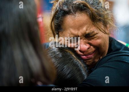 Uvalde, Texas, USA. 25.. Mai 2022. Eine Lehrerin der vierten Klasse an der Robb Elementary School in Uvalde, Texas, umarmt ihre Schülerin bei der Mahnwache für die Opfer der Massenschießerei an ihrer Schule, bei der 19 Schüler, 2 Erwachsene und der Schütze getötet wurden. Die Lehrerin sagte, dass ihr Klassenzimmer direkt neben dem Ort sei, an dem sich der Schütze verbarrikadierte, und sie sagte ihren Schülern, sie solle beten, nachdem sie Zuflucht genommen hatte. (Bild: © Jintak Han/ZUMA Press Wire) Stockfoto